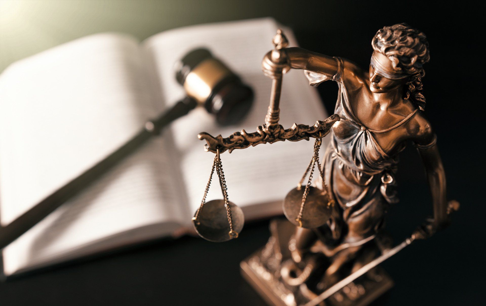 Statua in bronzo della Giustizia davanti a un codice aperto
